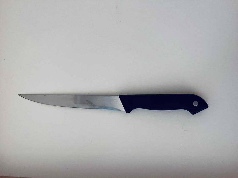 Kuchenmesser getestet: Messer mit schwarzem Griff liegt auf einer weißen Fläche.