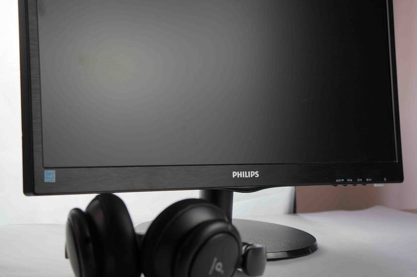 Vor einem getesteten Monitor liegt ein Kopfhörer