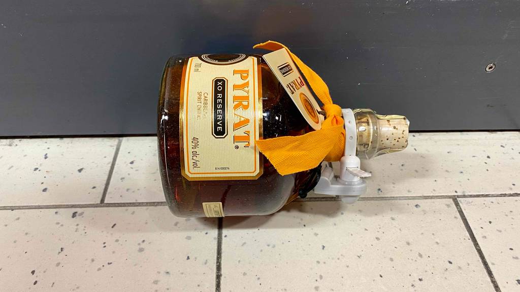 Cognac im Test: eine Flasche Cognac mit einem Korkenverschluss liegend auf einem Boden.