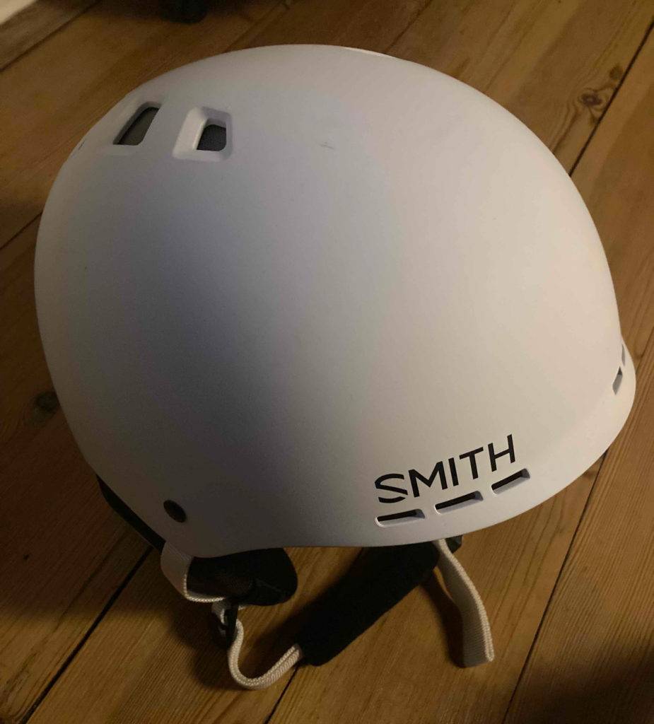 Snowboardhelm im Test: ein weißer Snowboardhelm liegend auf einem Boden.