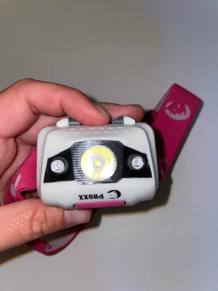 Stirnlampe wird in der Hand gehalten