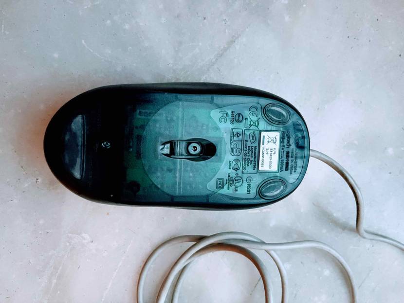 Eine getestete PC-Maus von unten auf einem hellen Stoff.