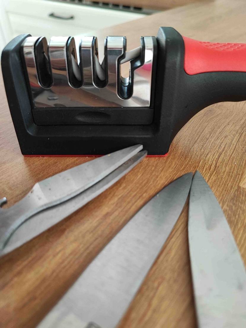 Zwei Messer und eine Schere liegen neben Messerschärfer