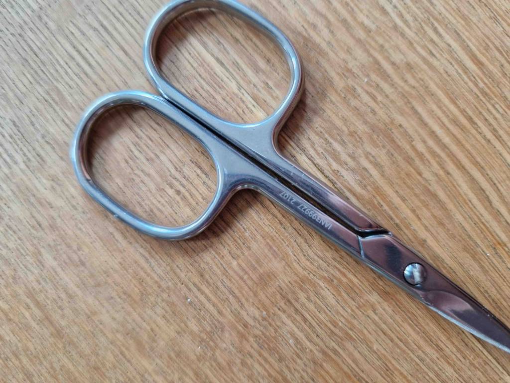 Nagelschere-Test: Geschlossene Nagelschere mit Gravierung auf einer Holzfläche.