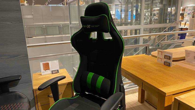 Ein getesteter Gaming-Stuhl von schräg seitlich vor einem Schreibtisch.