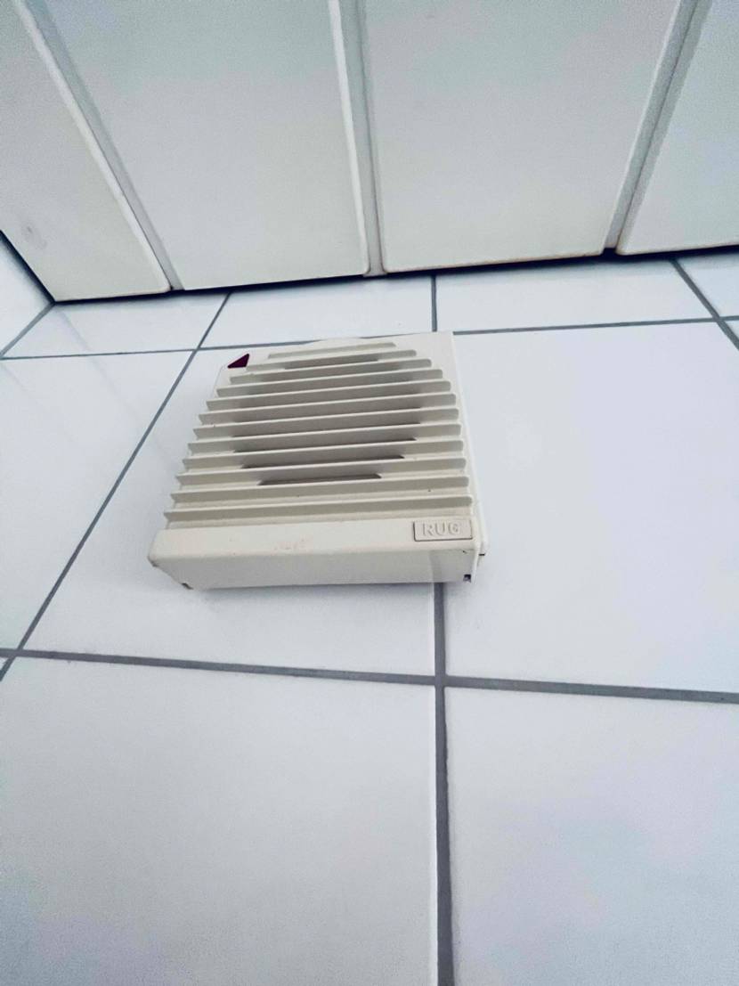 Badlüfter getestet: Ein Gerät von unten an einer Wand.