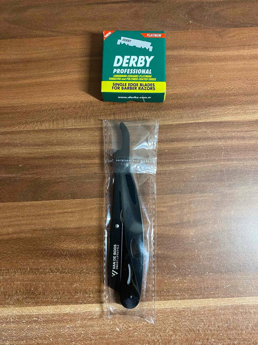 Rasiermesser getestet: Ein verpacktes Messer unter einer Packung Klingen auf einer Holzfläche.