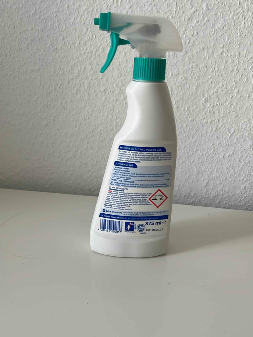 Rückseite einer Flasche getesteten Grillreinigers vor einer hellen Wand.