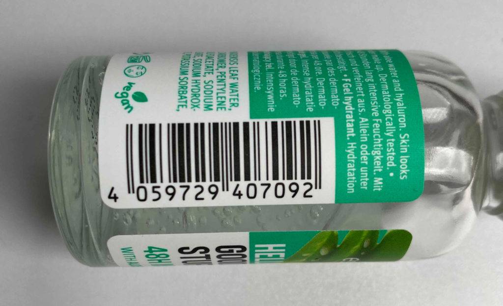 Liegendes Hyaluron-Serum auf grauer Oberflächen mit Strichcode.