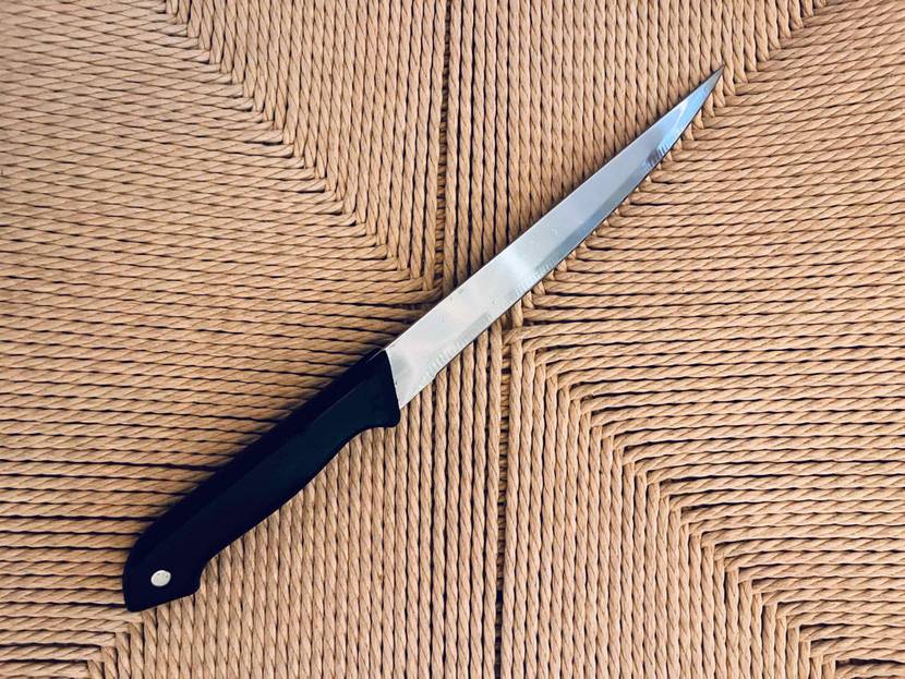 Kuchenmesser-Test: Kuchenmesser mit spitz zulaufender Klinge und schwarzem Griff liegend.