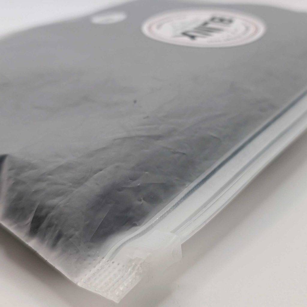 Getestete Periodenunterwäsche in Plastiktüte verpackt liegt auf einem weißen Tisch.