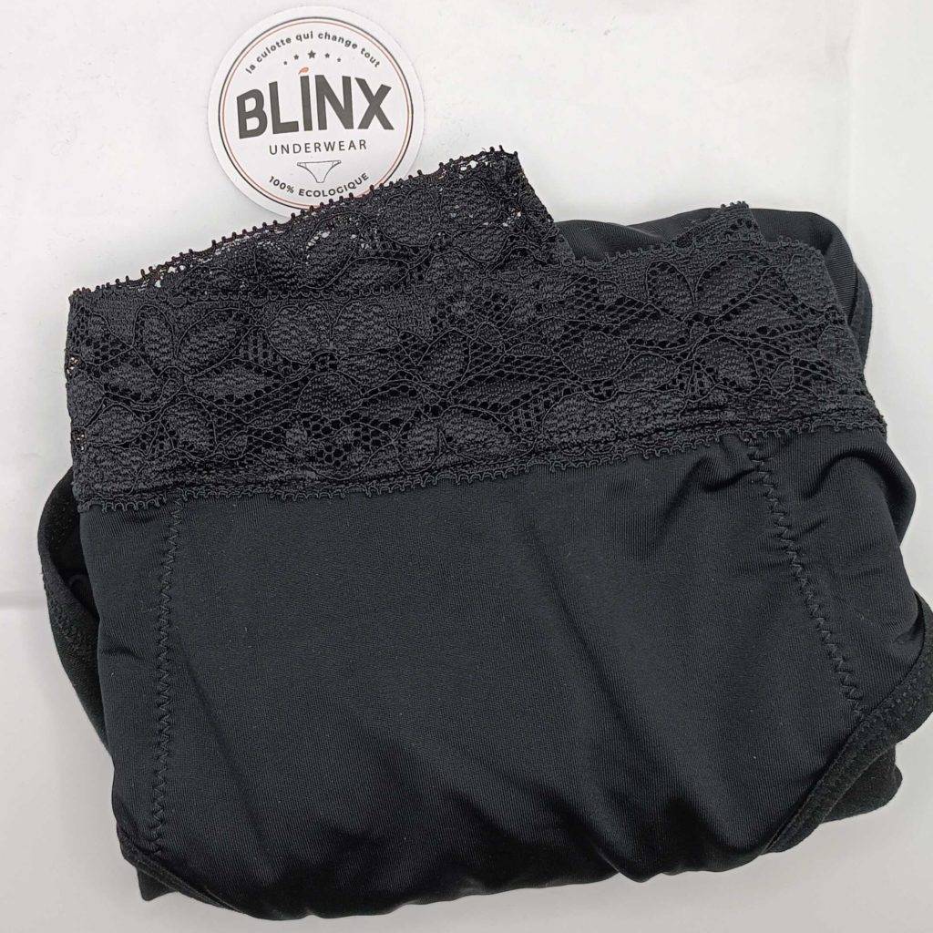 Periodenunterwäsche-Test: Schwarze Periodenunterwäsche mit Spitze liegt auf einem weißen Untergrund, wo oben links das Logo der Marke Blinx zu sehen ist.