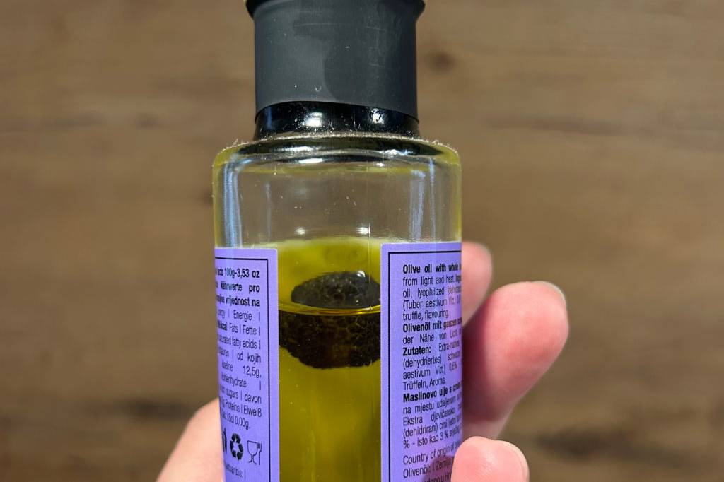 Trüffelöl in der Hand gehalten von der Seite.