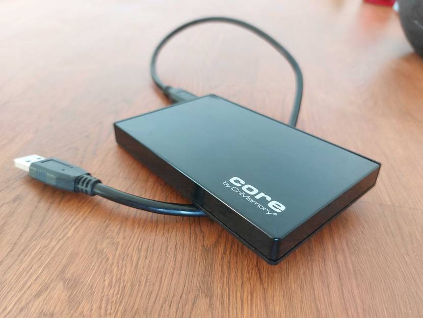 SSD Festplatte getestet: Eine SSD mit Kabel auf einer Holzfläche