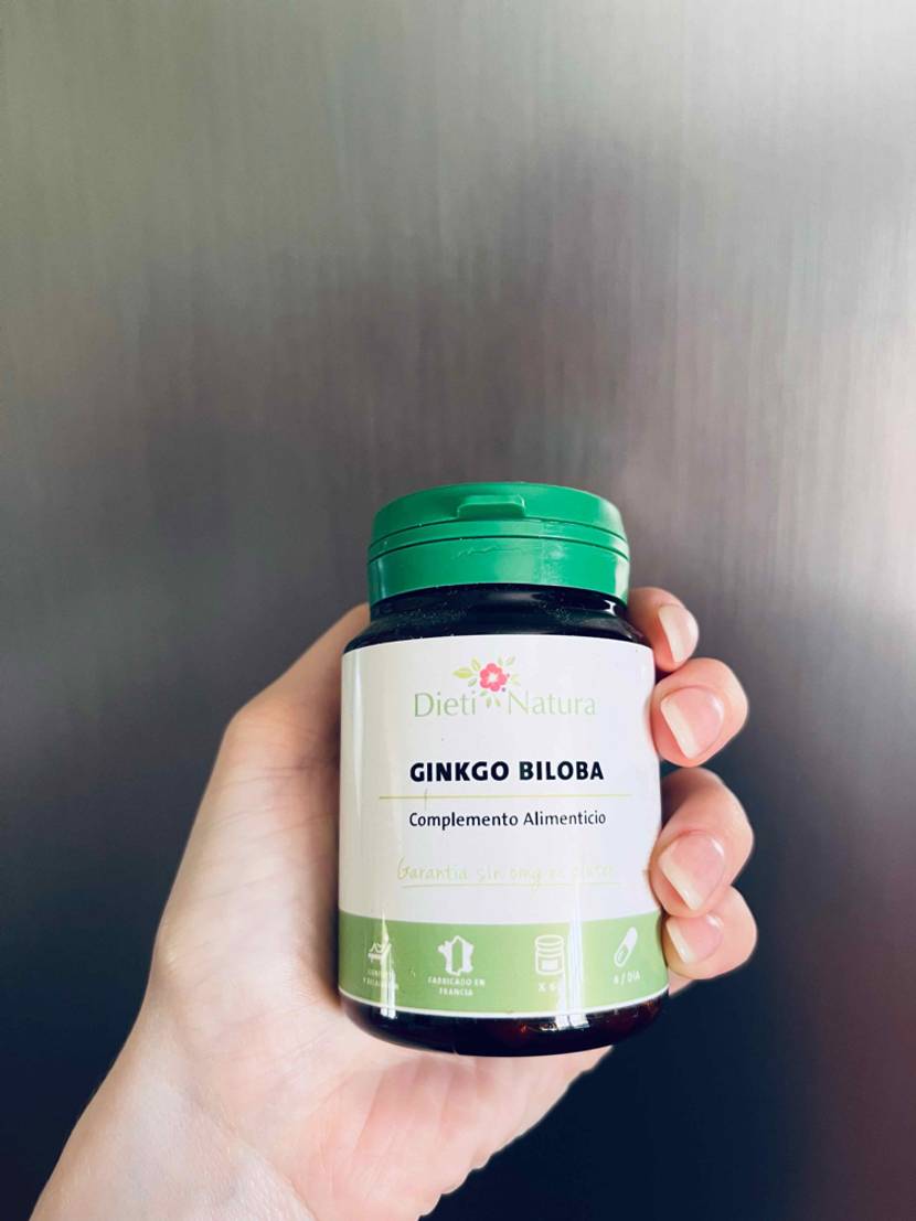 Im Test: Eine Hand hält eine Dose Ginkgo-Tabletten vor einen grauen Hintergrund.