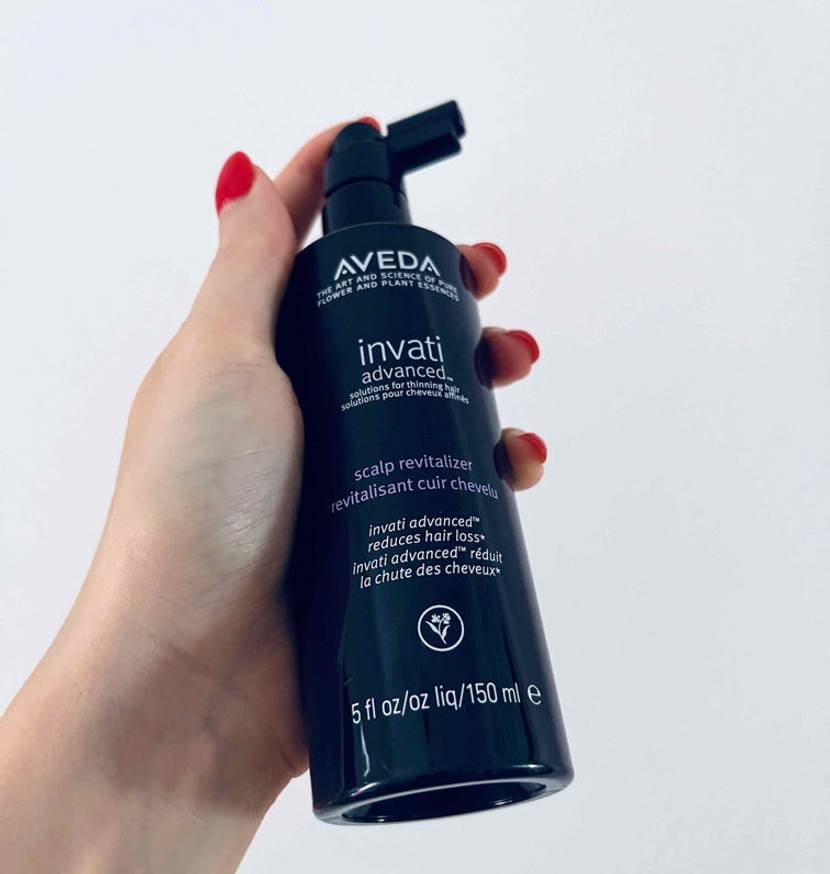 Haarwuchsmittel-Test: Haarwuchsmittel in Pumpspender in der Hand vor einem weißen Hintergrund.