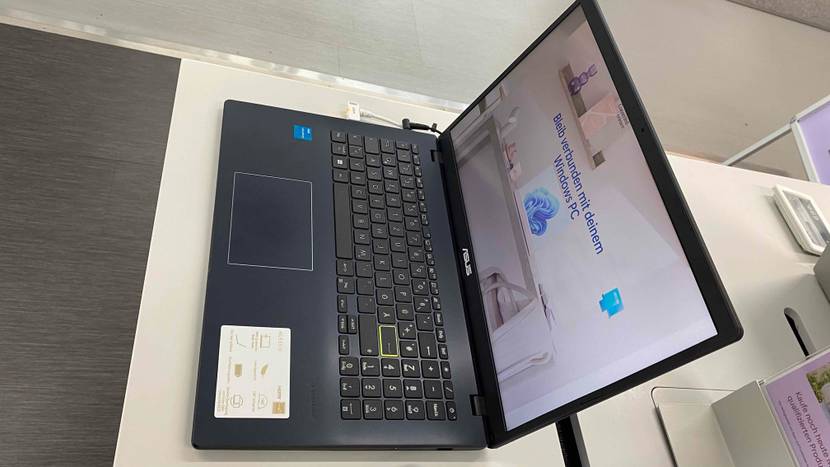 Günstiger-Laptop im Test: aufgeklappter Laptop eingeschaltet, mit Etikett auf dem Gerät steht in einem Geschäft.