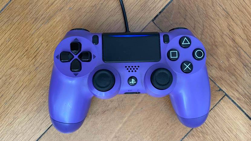 Ein getesteter PS4-Controller von oben auf einer Holzoberfläche.