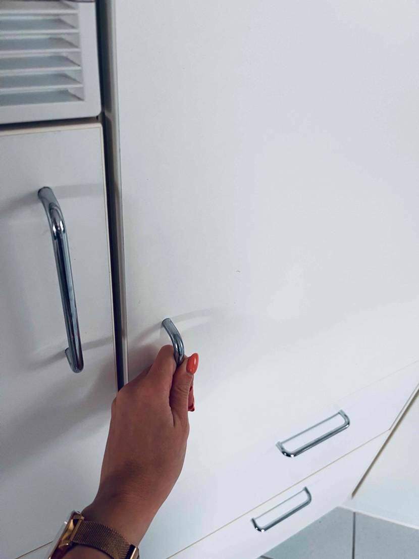 Einbaukühlschrank getestet: Eine Hand an dem Griff des Einbaukühlschranks.