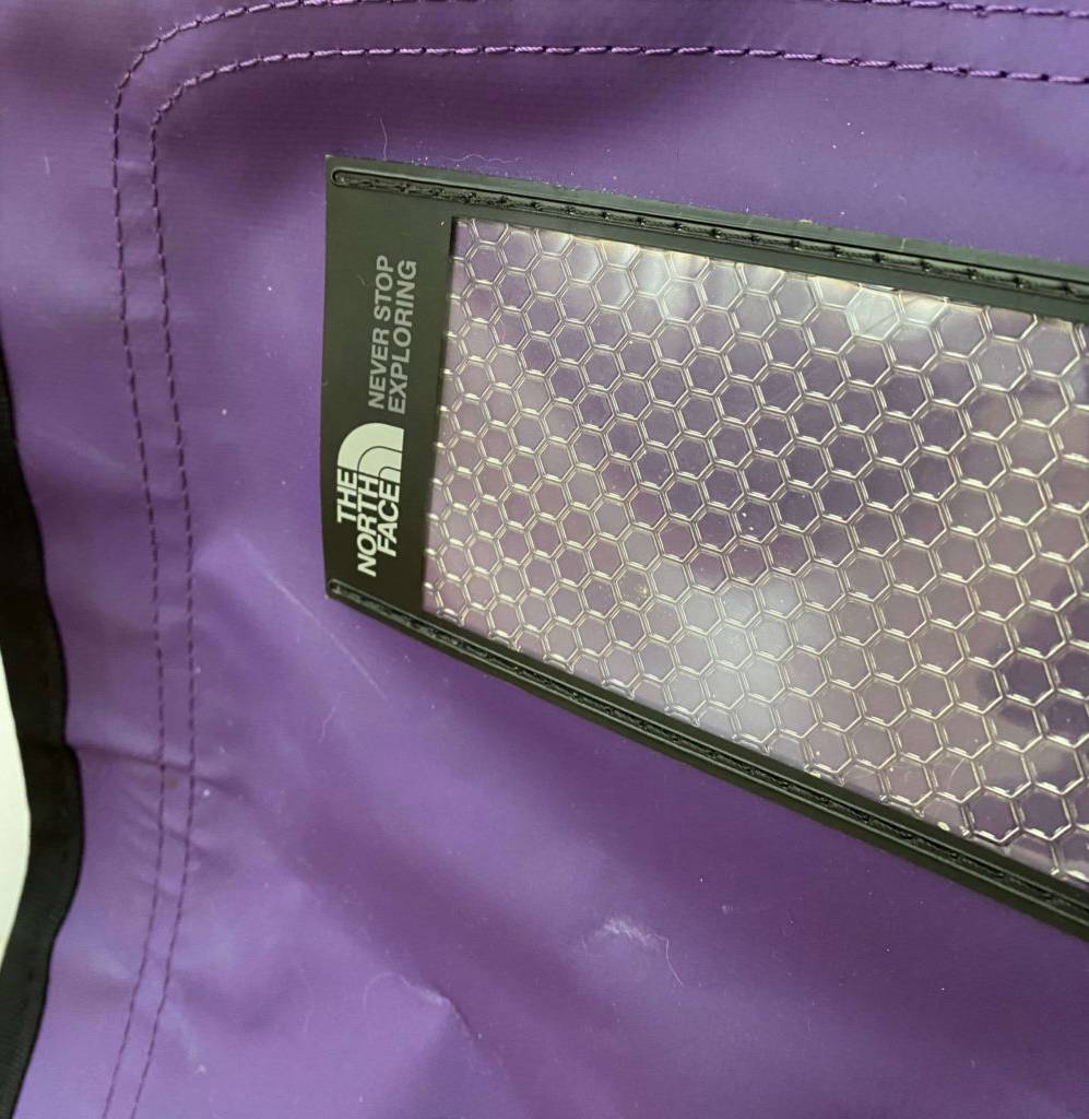 Reisetasche im Test: Detailaufnahme des lilafarbenen wasserfesten Stoffes einer North Face Reisetasche.