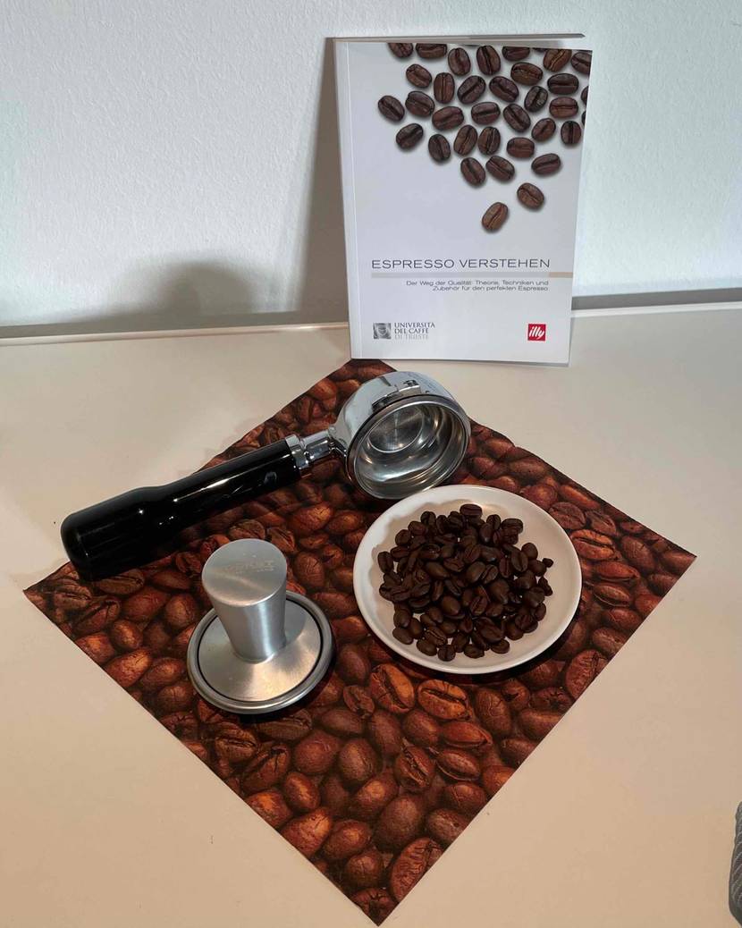 Espressobohnen getestet: Ein Buch lehnt an der Wand im Vordergrund ein Teller mit Bohnen ein Siebträger