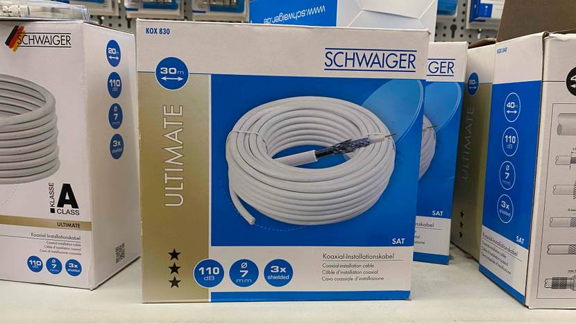 Ein gestestetes Koaxialkabel in seiner Verpackung auf einem Regal neben anderen.