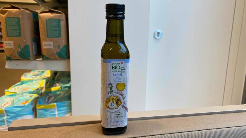 Eine Flasche getestetes Leinöl vor einer hellen Wand.
