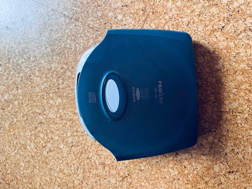 Auf einer Holzfläche steht ein geöffneter tragbarer CD-Player.