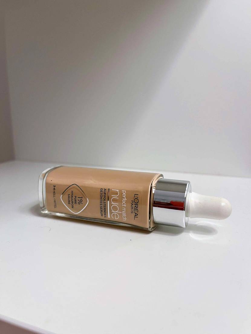 Make-up im Test: Eine Flasche Make-up liegt auf der Seite in einem weißen Regal