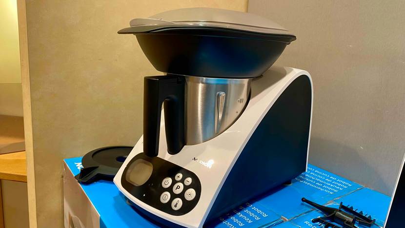 Eine getestete Küchenmaschine von schräg seitlich vor einer hellen Fläche.
