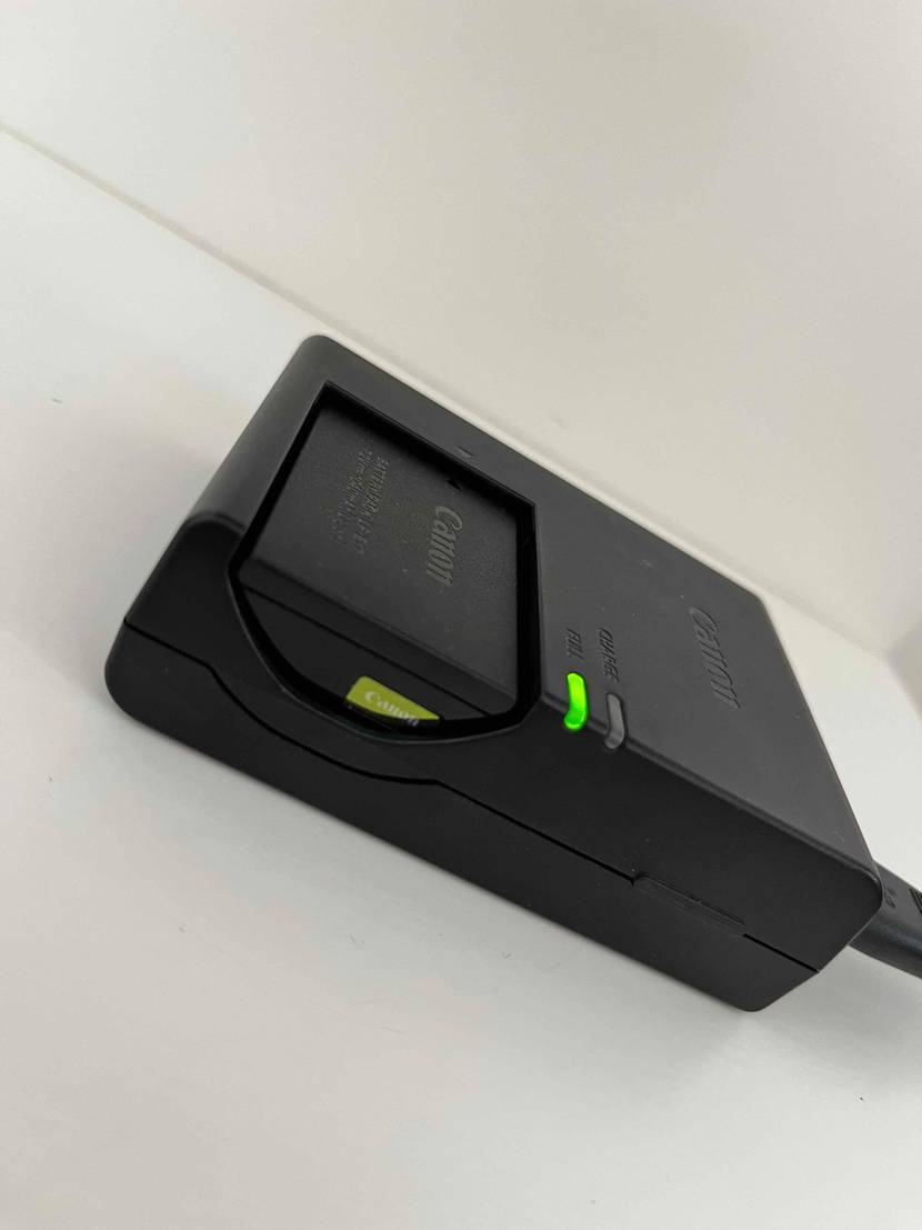 Akku-Ladegerät im Test: Ein Akku-Ladegerät mit ladendem Akku auf heller Fläche