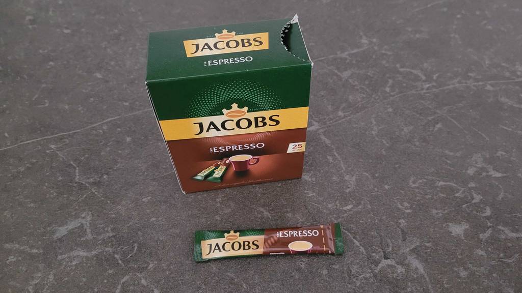 Verpackung und Espressosticks neben liegend auf einer grauen Oberfäche.