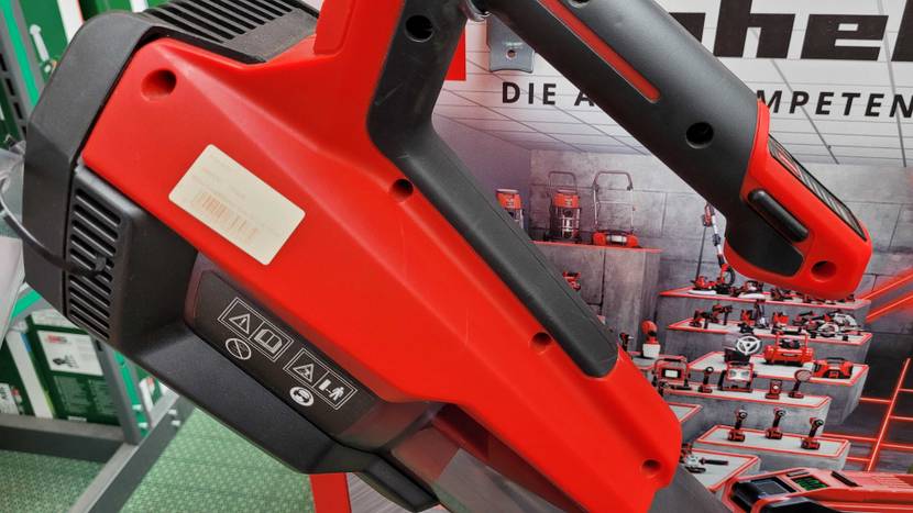 Akku Laubbläser getestet: Nahaufnahme des Griffes und des Motors vor einem Plakat.
