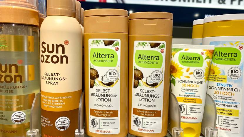 Selbstbräuner getestet: Mehrere Flaschen Selbstbräuner neben anderen Produkten in einem Verkaufsregal.