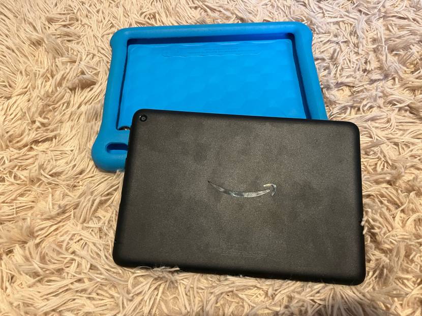 Im Test: Ein Kinder Tablet liegt leicht über einer blauen Hülle auf einem beigen Stoff.