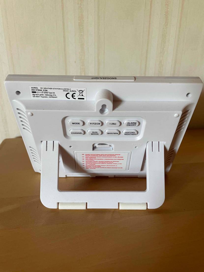 Getestete Wetterstation von hinten steht mit einem klappbaren Standfuß auf einem Holztisch.