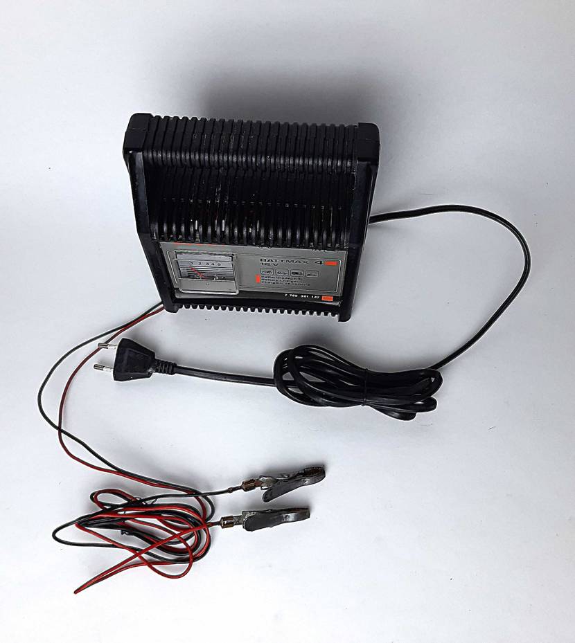 Das getestete Autobatterie-Ladegerät mit Kabeln von oben auf einer hellen Fläche.