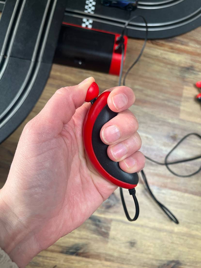 Autorennbahn im Test: Nahaufnahme der Fernbedienung in einer Hand.