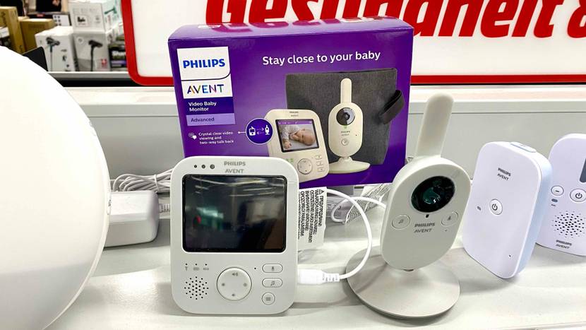 Ein getestetes Babyphone mit der Originalverpackung im Hintergrund auf einem hellen Regal in einer Verkaufsfläche.
