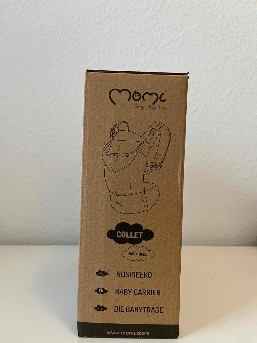 Babytrage MoMi im Test: Auf dem Karton ist die Babytrage abgebildet.