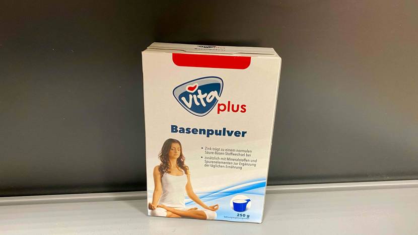 Eine Packung des getesteten Basenpulvers vor einer grauen Wand.