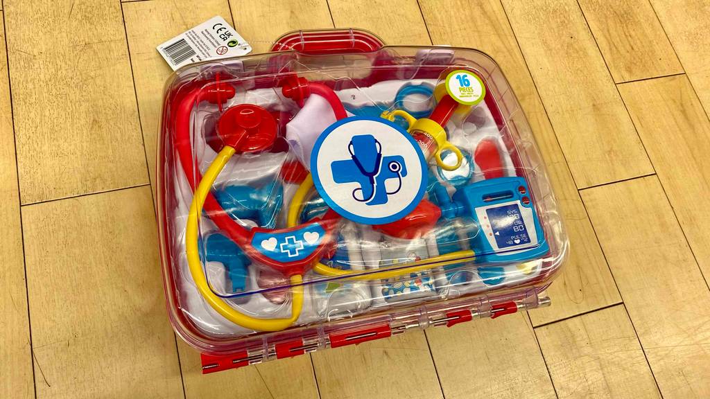 Getestet: Ein roter Arztkoffer für Kinder inklusive transparentem Deckel liegt auf einem Holzboden.