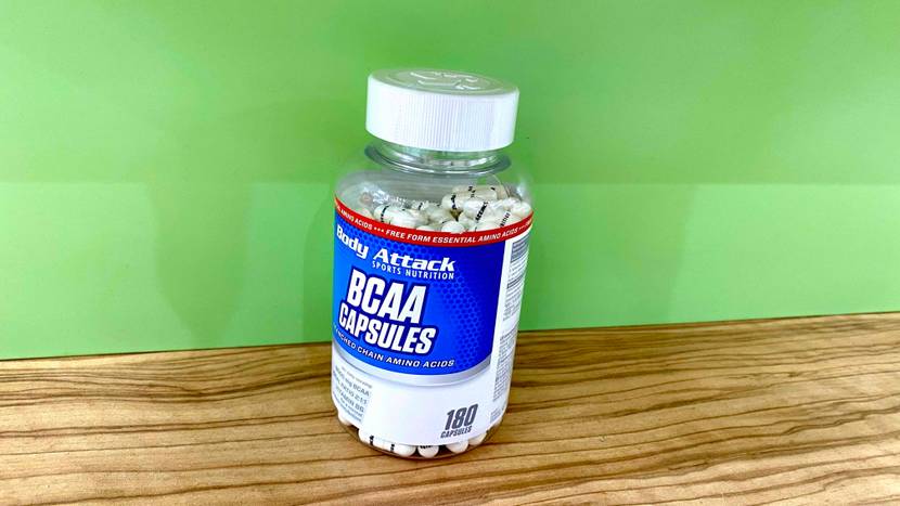 BCAA getestet: Eine Dose von vorne vor einer grünen Wand auf einer Holzfläche.