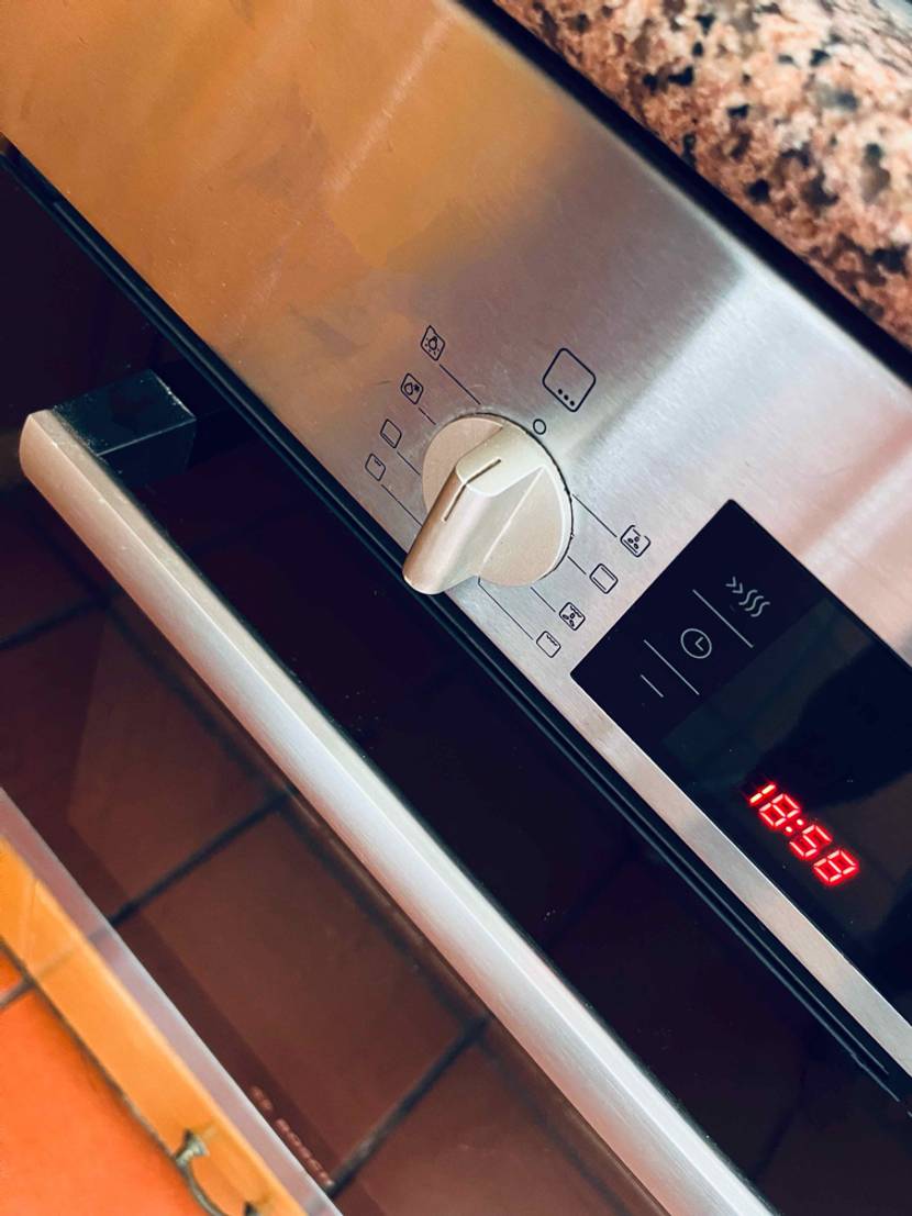 Sicht von schräg oben eines integrierten Backofens im Test: Funktionsregler und LCD-Anzeige mit Uhrzeit.