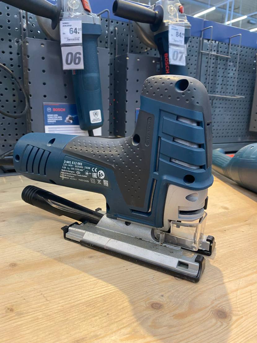 Im Test: Akku-Stichsäge von Bosch Professional im blauen Design steht auf Holz in einem Verkaufsbereich.