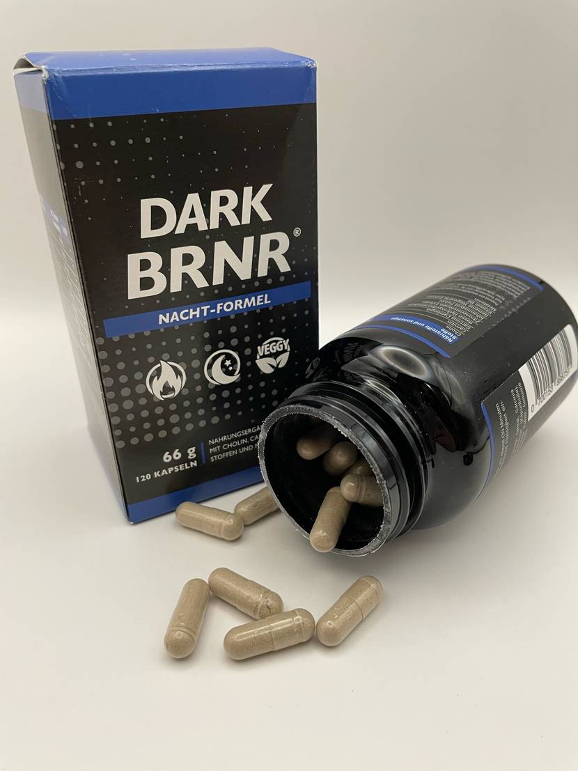 Vor dem Originalkarton liegt eine geöffnete Dose, davor liegen mehrere Kapseln Fatburner zum testen.
