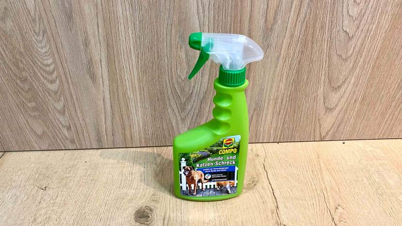 Im Test: Eine Flasche Katzenschreck steht vor und auf einer Holzfläche.