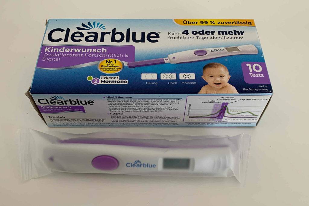 Ein verpackter Ovulationstest liegt vor dem Originalverpackungskarton von Clearblue.