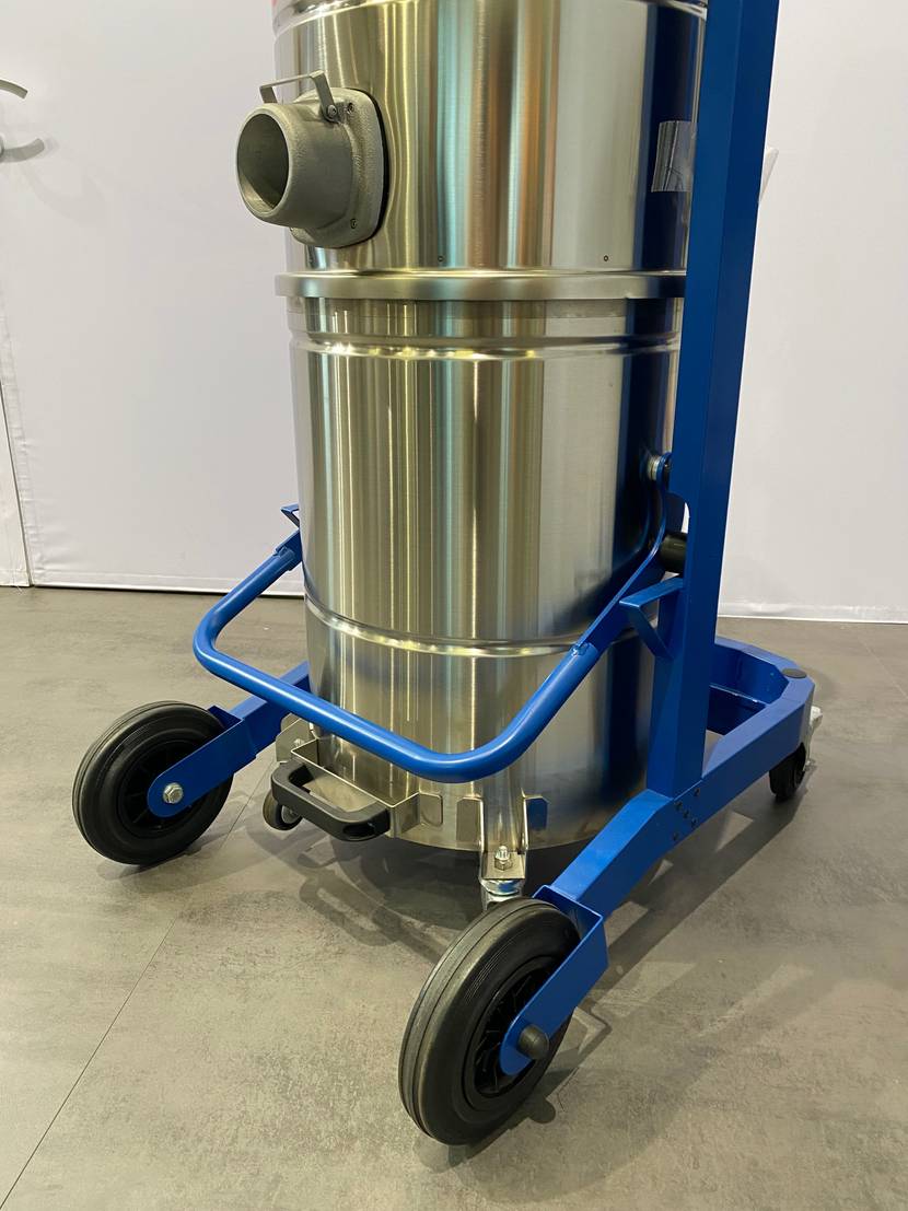 Edelstahl-Behälter inklusive Schlauchanschluss-Öffnung eines getesteten Industriestaubsaugers mit blau lackiertem Fahrgestell.