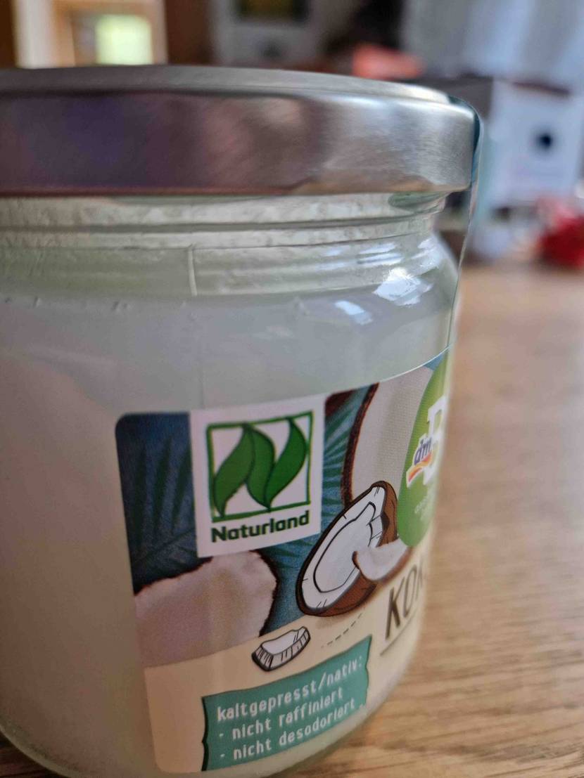 Getestet: Detailansicht Naturland Bio Kokosöl Glas, das auf einem Holztisch steht.